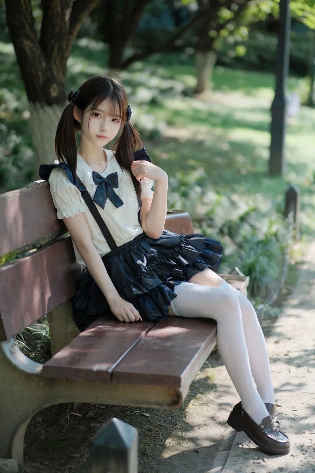 Girl in a Japanese school uniform sitting peacefully on a wooden park bench under dappled sunlight