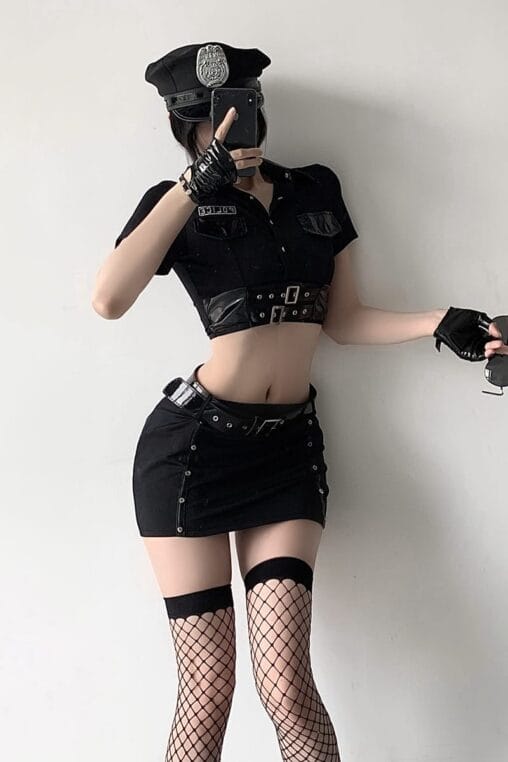 Model wearing a complete 9-piece gothic police officer cosplay lingerie outfit with hat, crop top, mini skirt, and fishnet stockings