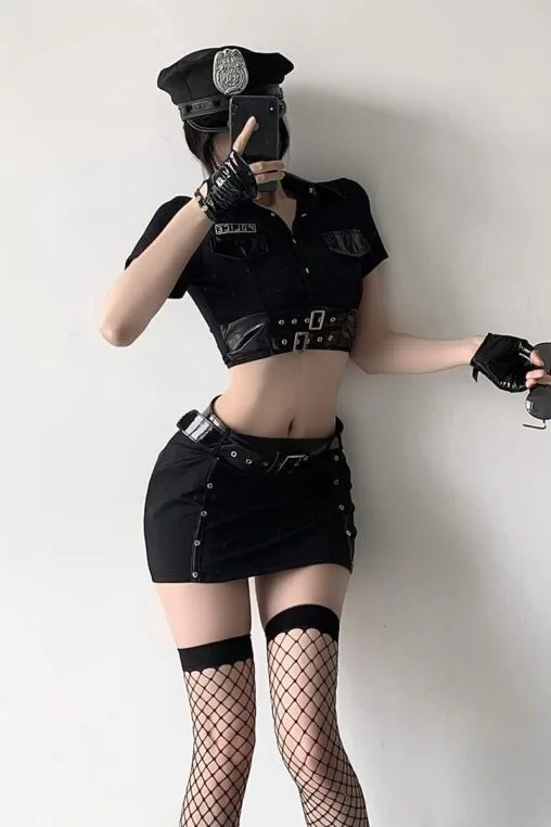 Model wearing a complete 9-piece gothic police officer cosplay lingerie outfit with hat, crop top, mini skirt, and fishnet stockings