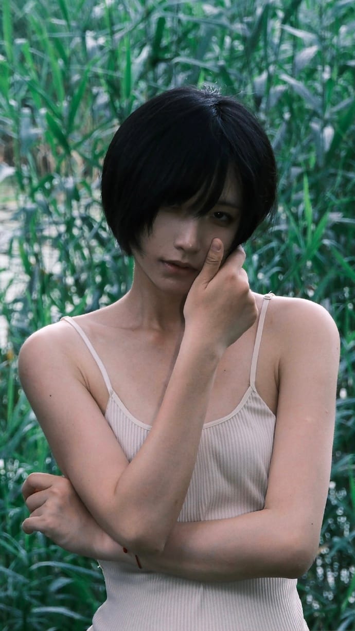 Close-up portrait of Ni-yoki with glowing skin and green garden background