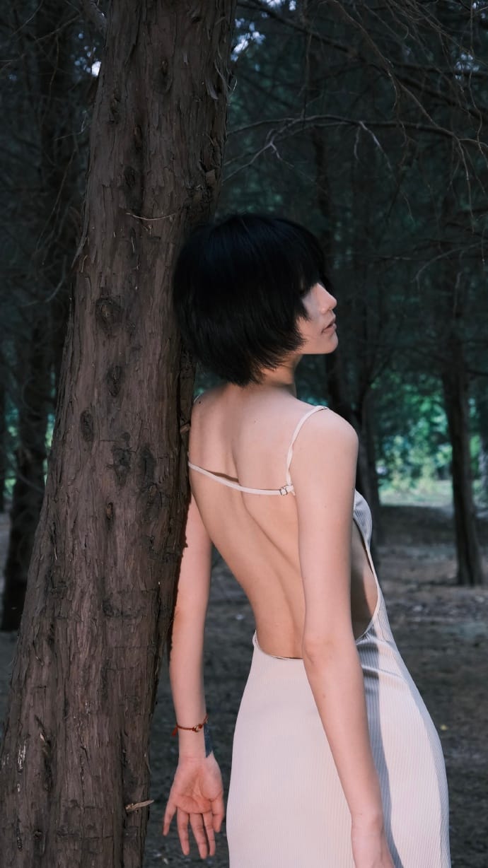 Full composition garden portrait of model Ni-yoki in a green scenic alley